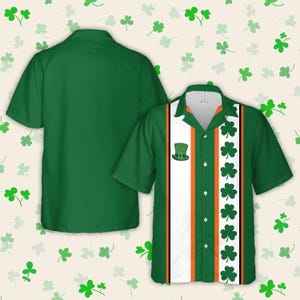 May include: Green and white short-sleeved button-up shirt with orange and black stripes and a shamrock pattern. The shirt has a green leprechaun hat with a buckle on the front.