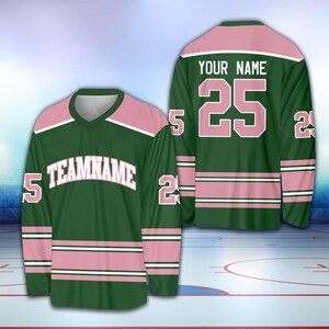 May include: Green and pink hockey jersey with white lettering. The jersey has the text "TEAMNAME" on the front and the number "25" on the back. The text "YOUR NAME" is above the number on the back.