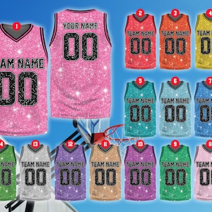 Könnte beinhalten: Ein Set aus 14 Basketballtrikots in Pink, Grün, Blau, Lila und Gold mit Glitzer. Die Trikots tragen den Text "TEAM NAME" und "YOUR NAME" mit den Nummern 00 auf der Vorderseite.
