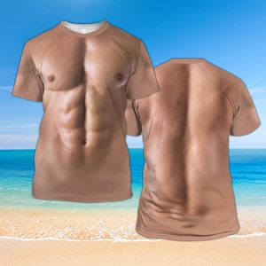 Puede incluir: Una camiseta marrón con una imagen impresa de un torso musculoso en la parte delantera y trasera. La camiseta está fotografiada sobre un fondo de cielo azul y océano.