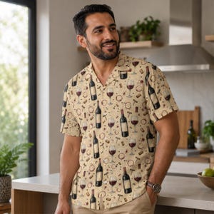 Puede incluir: Camisa beige de manga corta con un estampado temático de vino. El diseño incluye ilustraciones de botellas de vino, copas de vino tinto, sacacorchos y manchas de vino. La camisa tiene un cuello clásico y un corte relajado.