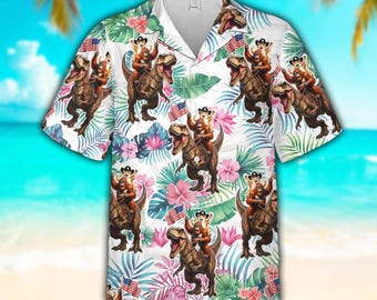 Camisa hawaiana patriótica de dinosaurios para hombres y mujeres, camisa hawaiana con bandera de EE. UU., vaquero, gato y T-Rex, camisa tropical de dinosaurios para el 4 de julio con botones.