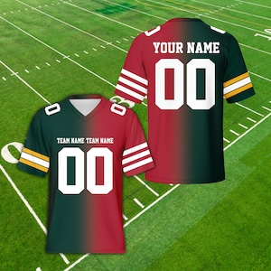 Puede incluir: Dos camisetas de fútbol americano, una delante y otra detrás, con una combinación de colores verde y rojo. Cada camiseta tiene el número "00" en blanco. Una camiseta tiene "YOUR NAME" impreso encima del número, y la otra tiene "TEAM NAME TEAM NAME".