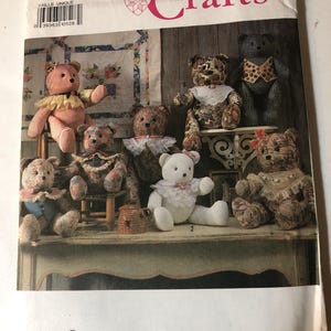 May include: Simplicity Crafts pattern featuring various handmade teddy bears. The bears are in different colors and patterns, some with frilly collars and decorative vests. The pattern is labeled "9894" and "ONE SIZE".