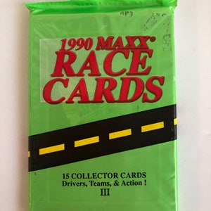 May include: A green sealed pack of 1990 MAXX Race Cards. The pack features a black and yellow road design with the text "1990 MAXX RACE CARDS" in red letters. The text "15 COLLECTOR CARDS Drivers, Teams, & Action! III" is printed in black letters on the bottom of the pack.