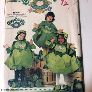 May include: Vintage Butterick sewing pattern for Cabbage Patch Kids costumes. The pattern features three children dressed in green cabbage-shaped outfits. The packaging includes the Cabbage Patch Kids logo and the number 6920.