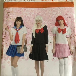 May include: Simplicity sewing pattern number 8160, size US 4, 6, 8, 10, 12, talla euro 30-38, taille fr 32-40, for a school girl costume with three different skirt options: blue, black, and pink.