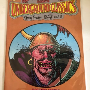 May include: A comic book cover featuring a cartoon illustration of a large, red-skinned, bearded man with a horned helmet. The comic book is titled "Underground Classics" and features the text "Greg Irons early work vol. 2". The cover is orange and has the text "Adults Only" at the bottom.