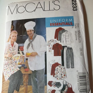 May include: A McCall's M2233 sewing pattern envelope for Uniform Essentials, size Medium (38-40). The front features illustrations of chef jackets, pants, aprons, and hats, alongside a photograph of two people wearing the finished garments.