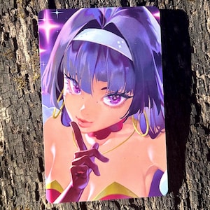 May include: A purple-haired woman with a white headband and a gold necklace. She is wearing a red and gold costume and has a finger to her lips. The background is a purple and blue gradient with stars.