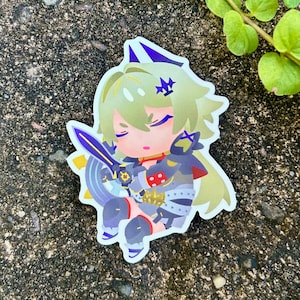 May include: A sticker of a cartoon character with green hair, wearing a black and gold outfit, holding a sword. The character has a crown on their head and is looking down.