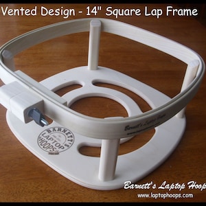 May include: A 14-inch square wooden lap frame with a vented design. The frame is made of natural wood and has a white finish. The frame is designed to hold fabric taut for embroidery or other crafts.
