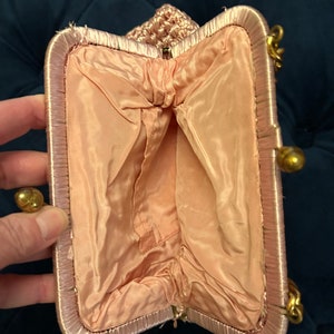 May include: A pink crocheted evening bag with a satin lining and a gold clasp.