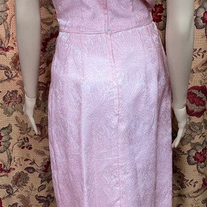 May include: A pink, sleeveless dress with a floral pattern. The dress has a V-neckline and a back zipper closure.