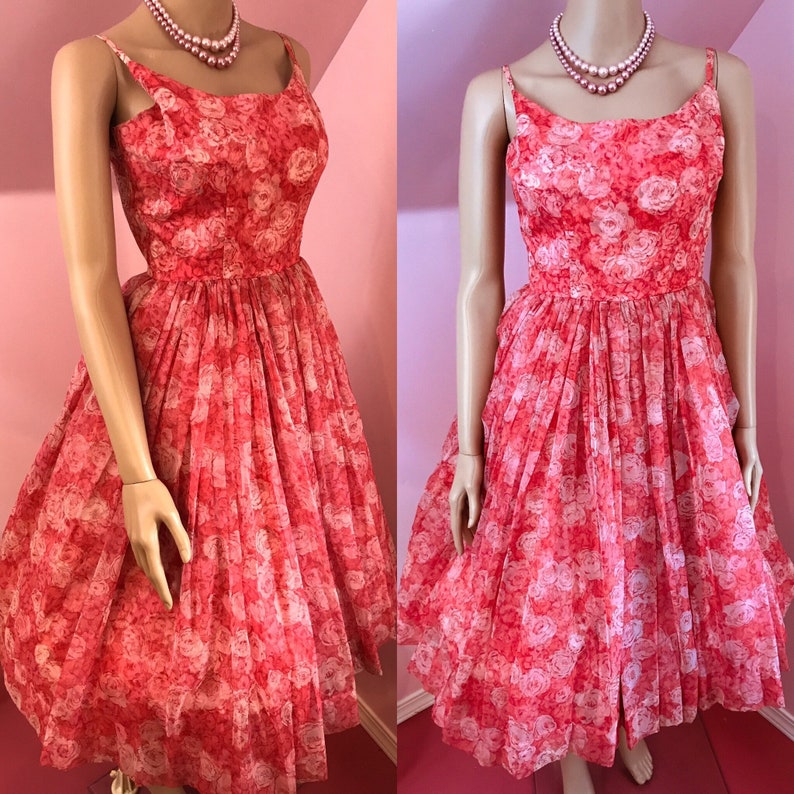 K&ouml;nnte beinhalten: Ein Vintage-Kleid in Rosa und Wei&szlig; mit Blumenmuster, vollem Rock und Spaghettitr&auml;gern.