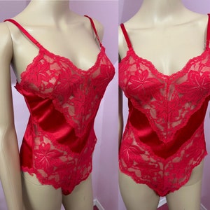 May include: Red satin and lace lingerie with adjustable straps. The lingerie has a V-neckline and a floral lace design.