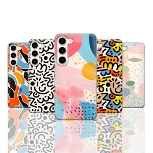 Op de afbeelding: Vijf verschillende telefoonhoesjes met abstracte ontwerpen. De hoesjes zijn allemaal transparant en laten het ontwerp van de telefoon zien. De ontwerpen omvatten kleurrijke geometrische vormen, abstracte patronen en een aquarelontwerp.