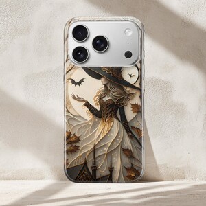 May include: Clear phone case featuring a witch illustration. The artwork depicts a woman in a black hat and dress, with a bat and autumn leaves. The background includes a full moon and a cityscape. The case is designed for a smartphone.
