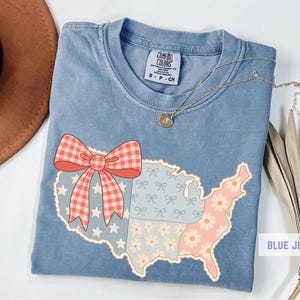 a blue shirt with a red bow and a map of the united states