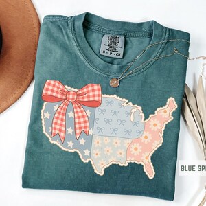 a t - shirt with a map of the united states with a bow on it