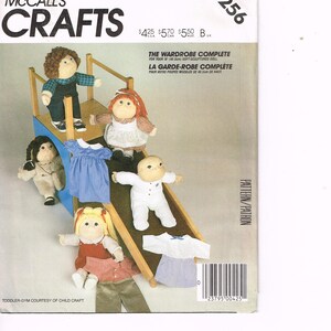 May include: A vintage McCall's Crafts pattern for a doll wardrobe, featuring a variety of doll clothing and a toddler gym. The cover displays several soft-sculptured dolls wearing the outfits. The pattern number is 9256.