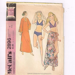 Może przedstawiać: Vintage wzór krawiecki McCall's 2896 z ilustracjami koordynowanych zestawów dla juniorów. Wzór zawiera projekty pomarańczowej sukienki, niebieskiego bikini i kwiatowej spódnicy kopertowej. Okładka zawiera tekst "It's Young Fashion".