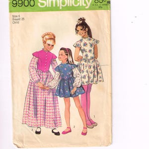 Könnte beinhalten: Vintage Simplicity Schnittmusterumschlag. Der Umschlag ist grün und weiß mit der Nummer 9900. Die Illustration zeigt drei junge Mädchen in Kleidern. Der Text auf dem Umschlag lautet "Größe 6 Brust 25 Kind".