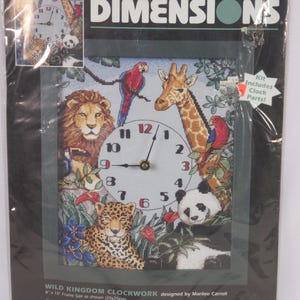 May include: A counted cross-stitch kit featuring a clock design with a wild kingdom theme. The clock face is surrounded by a lion, giraffe, leopard, panda, and parrots. The kit includes clock parts and is designed by Marilee Carroll. The frame size is 8 x 10 inches.