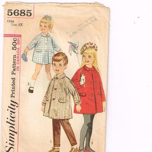 Könnte beinhalten: Vintage Simplicity-Schnittmusterumschlag mit Illustrationen von Kinderjacken und -kleidern. Der Umschlag zeigt die Nummer 5685 und die Größe 6X. Das gedruckte Muster kostet 50 Cent in Kanada.