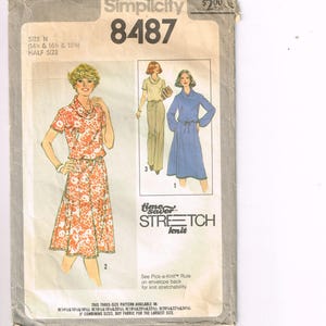 May include: Vintage Simplicity sewing pattern 8487. The pattern envelope features illustrations of three different dress designs. The main image shows a woman in a floral print dress. The text on the envelope reads "Stretch Knit".