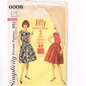 Può includere: Busta di cartamodello Simplicity vintage con illustrazioni di due abiti a palloncino. La busta è gialla con il testo "Jiffy bouffant dress" e "3 main pattern pieces". Il modello è taglia 11, circonferenza torace 80 cm.