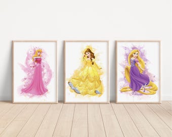 May include: Three framed prints featuring Disney princesses. The prints are on a white background with watercolor-style designs. The princesses are Aurora, Belle, and Rapunzel. Each princess is wearing a gown in their signature colors.