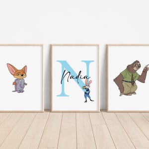 Puede incluir: Tres impresiones enmarcadas con un fondo azul. La impresi&oacute;n de la izquierda presenta un zorro de dibujos animados con un mono morado. La impresi&oacute;n del medio presenta una letra N azul con el nombre Nadia escrito en cursiva negra. La impresi&oacute;n de la derecha presenta un perezoso de dibujos animados con una camisa verde y pantalones marrones.