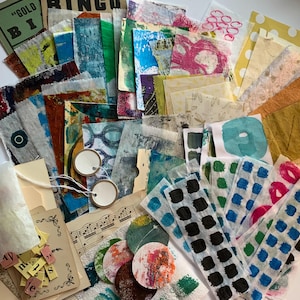 May include: A collection of colorful mixed media art supplies, including patterned paper, tags, and ephemera. The assortment features various textures, colors, and designs, with some pieces bearing text and musical notes. The color palette includes blues, greens, pinks, and yellows.