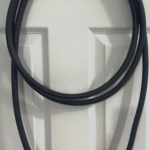 May include: A black electrical extension cord with two standard three-prong plugs.