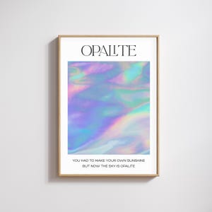 Könnte beinhalten: Ein gerahmter Kunstdruck mit dem Wort "OPALITE" oben. Das Kunstwerk zeigt ein lebendiges, schillerndes abstraktes Design in Blau-, Grün- und Lilatönen. Der untere Teil des Drucks lautet: "YOU HAD TO MAKE YOUR OWN SUNSHINE BUT NOW THE SKY IS OPALITE."