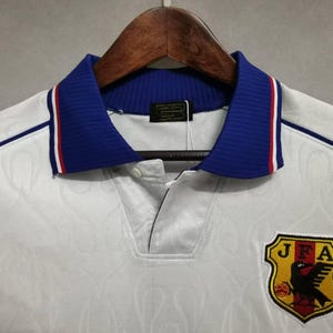 Japan 1998 jersey
Retro Japan shirt
Vintage Japan kit
Samurai Blue 1998
Japan World Cup 98
Classic Japan shirt
Japan away jersey 98
Japan football shirt
Flame design jersey
JFA 1998 kit
Retro soccer top
World Cup Japan shirt
Japan national team kit