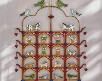 Puede incluir: Decoración mural de varios niveles con figuras de madera pintadas. Presenta caballos, tigres, pájaros y personas en colores brillantes. Acentos rojos, dorados y azules enmarcan las figuras, con adornos en forma de corazón.