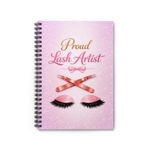 May include: Spiral-bound notebook with a pink cover featuring the text "Proud Lash Artist" in gold and pink script. The design includes crossed tweezers, a pink bow, and stylized eyelashes. The background has a glitter effect.