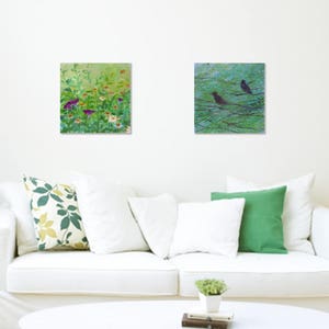May include: Two framed paintings, one depicting a green field of wildflowers and the other a green forest with two black birds perched on branches.