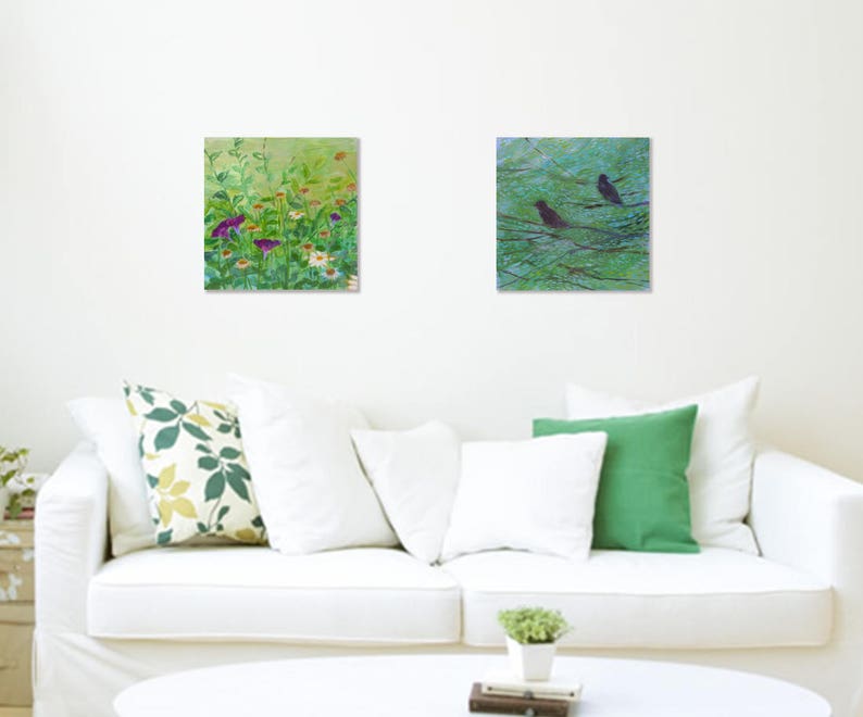 May include: Two framed paintings, one depicting a green field of wildflowers and the other a green forest with two black birds perched on branches.