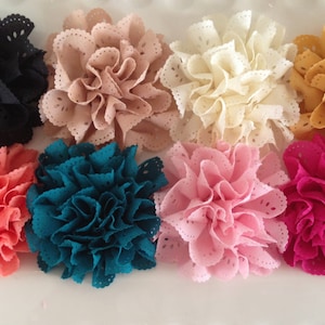 May include: Eight fabric flowers in various colors, including black, beige, cream, gold, coral, teal, pink, and magenta. The flowers are all made of a soft, ruffled fabric with a delicate lace trim.