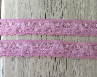 May include: Two pieces of pink elastic lace trim with a scalloped edge and a delicate floral pattern.