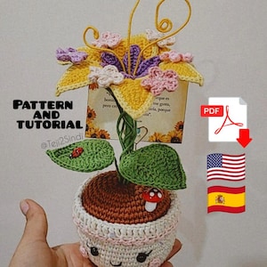 Puede incluir: Una maceta de ganchillo con una cara sonriente, que sostiene una flor de ganchillo con pétalos amarillos, morados y rosas. Las hojas tienen una mariquita y una seta. El texto de la imagen dice "PATTERN AND TUTORIAL".