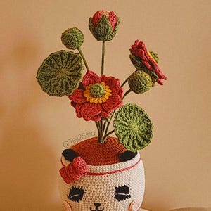 パンダの鉢に入った蓮の花、パンダの編みぐるみ、編み物の花、先行販売週のスペイン語のパターンとチュートリアル