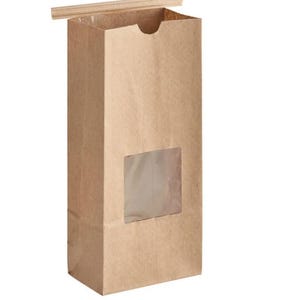 May include: A tall, rectangular brown paper bag with a clear window and a wooden closure. The bag is made of kraft paper and is designed to stand upright. The window allows a view of the contents.