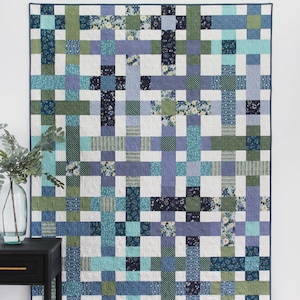 Peut inclure: Un modèle de courtepointe appelé "Hashtag" avec un motif de patchwork en tissus bleus, verts et blancs. Le modèle est décrit comme une "courtepointe en quartiers gras en 4 tailles".