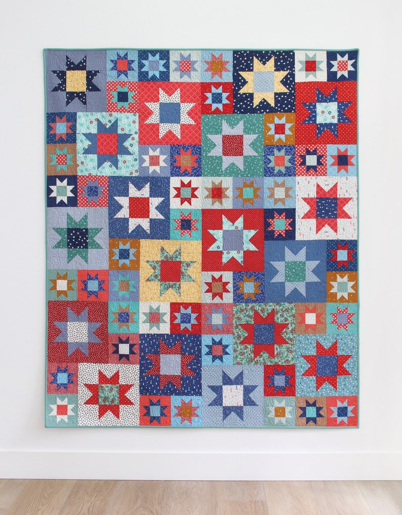 May include: A quilt with a patchwork design featuring a variety of colorful fabrics. The quilt is made up of squares with stars in the center. The stars are in various colors, including red, blue, yellow, and green. The quilt is bordered in a light blue fabric.