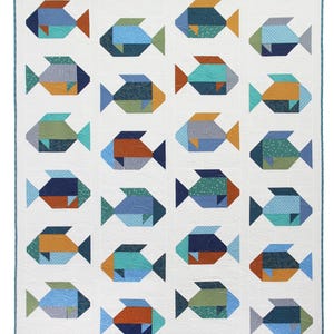 May include: A white quilt featuring a repeating pattern of geometric fish in shades of blue, orange, and green. The fish have various patterned details, including stripes and dots. The quilt has a light blue border and a wavy quilted texture.