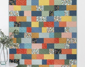 May include: A quilt pattern called "Sidewalk" featuring a colorful patchwork design with a variety of floral prints. The quilt is made with fat quarters and is available in five sizes. The pattern is from Cluck Cluck Sew.